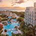 Sonesta Maho Beach Resort Casino & Spa in Lowlands with ocean view, pools and palm trees at sunset