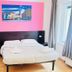 L'Affittacamere di Venezia bedroom with double bed, pink accent wall, and window in Venice