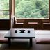Shima Grand Hotel in Nakanojo with tatami seating and large windows overlooking lush green trees.