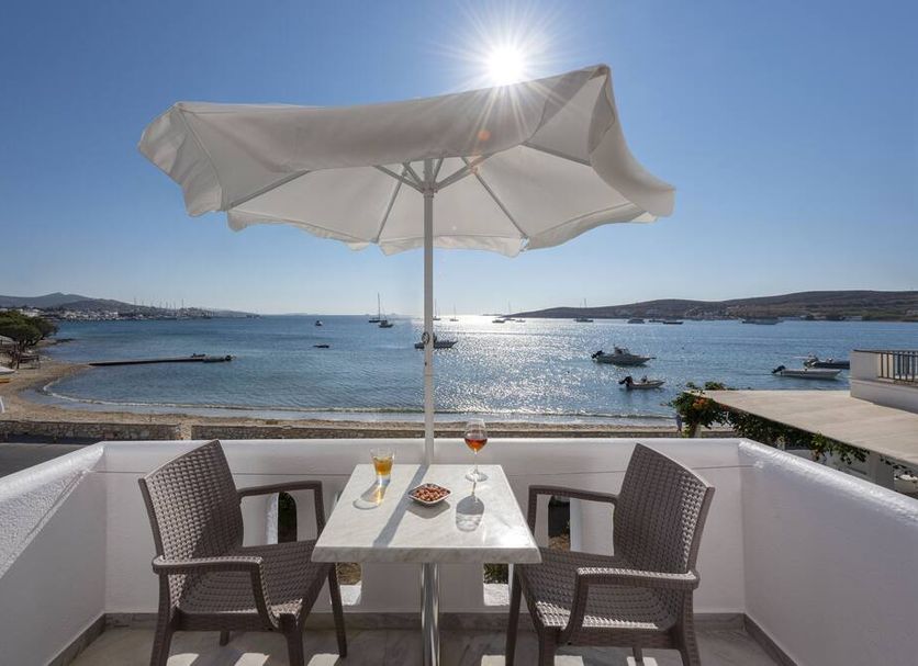 Irene Hotel - Beachfront in Parikia: seaside terrace table with umbrella overlooking calm bay and boats