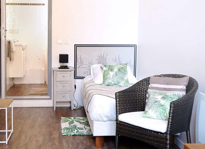 Hôtel Croix Baragnon Toulouse guest room with single bed, wicker chair, and open bathroom door