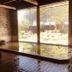Onsen Yupopo in Semboku: indoor hot spring bath with large window views of a garden