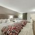 Red Roof Inn Kingsport guest room with two beds, TV, dresser and window curtains