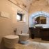 Almapetra Trulli Resort bathroom in Locorotondo with stone arched ceiling, bidet and vanity