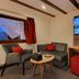 Gasthaus Staude in Triberg: cozy room with sofa, TV, desk, and window with mountain view