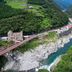 Hotel Obokekyo Mannaka in Miyoshi beside a turquoise river gorge with a red bridge and forested hills