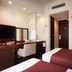 S Peria Hotel Nagasaki room with twin beds, desk, TV and bathroom entrance in Nagasaki