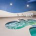 Wingate by Wyndham Sheboygan indoor pool with adjoining hot tub and white table chairs
