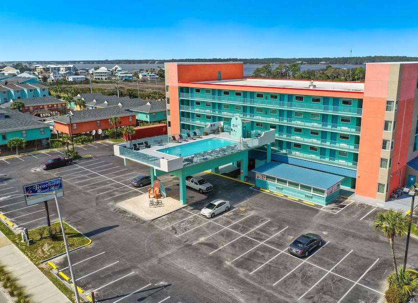 Beachside Resort Hotel in Gulf Shores with turquoise balcony rooms, pool and large parking lot