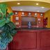 Quality Inn & Suites Westminster Seal Beach lobby front desk with red wood counter and yellow walls