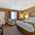 Quality Inn & Suites Westminster Seal Beach guest room with king bed and seating area