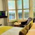 A Room With A View Brighton guest room with twin beds, window shutters and city view