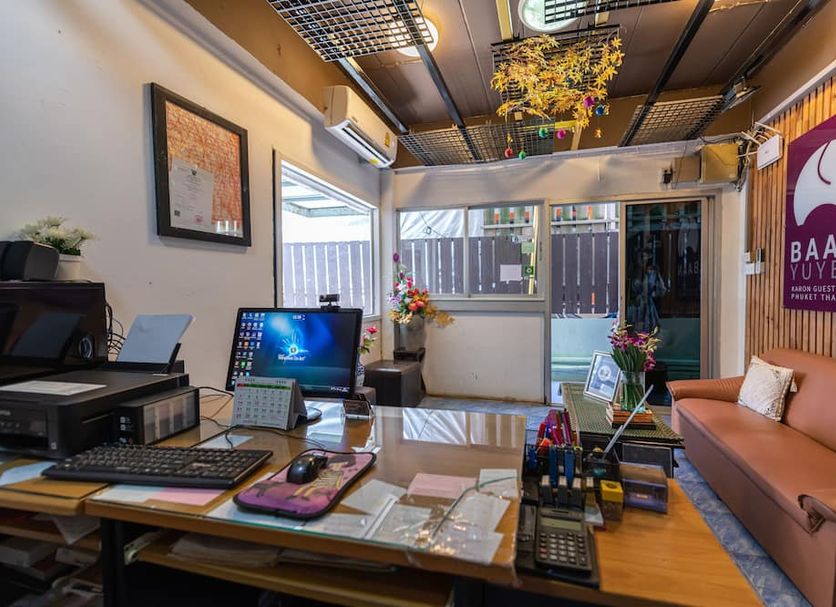 Baan Yuyen Karon Guesthouse reception desk with seating area and colorful decor in Karon