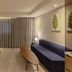Hotel Londoner Gwanganlli in Busan guest room with sofa, desk, wall TV and curtained window