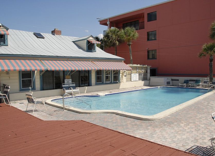 Gulf Towers Resort Motel in Indian Rocks Beach with an outdoor pool beside a red building