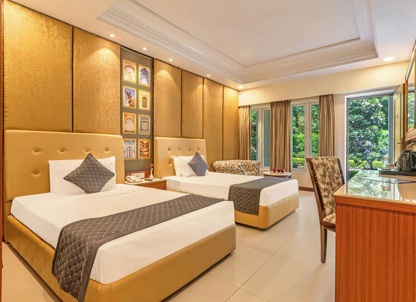 Sterling Amargarh Jodhpur guest room with two beds, desk, and garden-view windows in Jodhpur