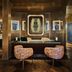 Seda Club Hotel Granada lounge with wood-paneled bar, pink chairs and framed wall art