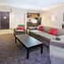 Holiday Inn & Suites Red Deer South living room suite with sofa, chairs, coffee table and kitchenette