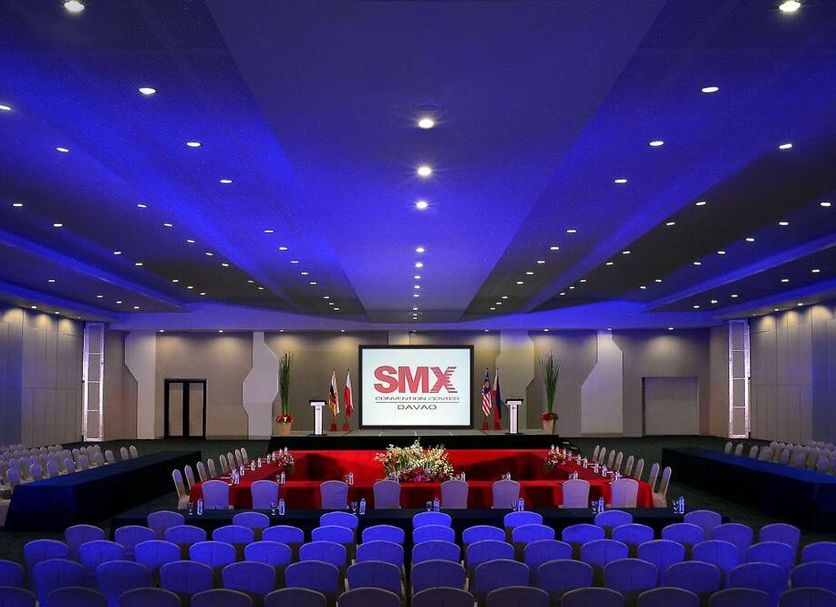 Alu Hotel Davao meeting room with stage, screen, and rows of blue chairs in Davao City