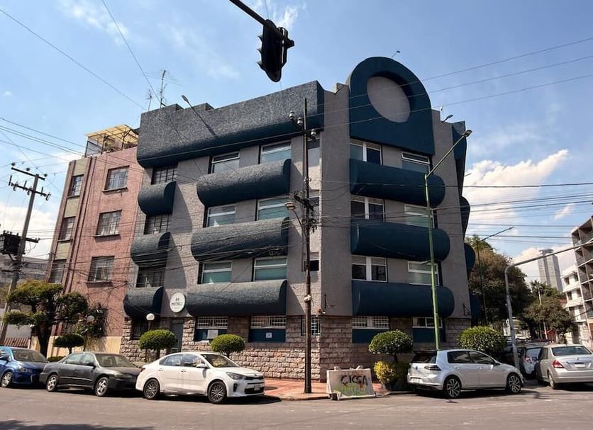 Hotel Muy Cdmx in Mexico City, exterior of a modern multistory hotel with balconies and parked cars