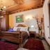 Brilant Antik Hotel in Tirana: ornate wood-paneled bedroom with four-poster bed, desk, and window seating