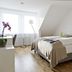 Burgblick in Bernkastel-Kues, bright guest room with double bed, wood floor, and window light