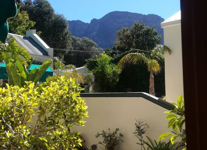 Newlands Guest House, Cape Town patio view with mountain backdrop and lush garden greenery