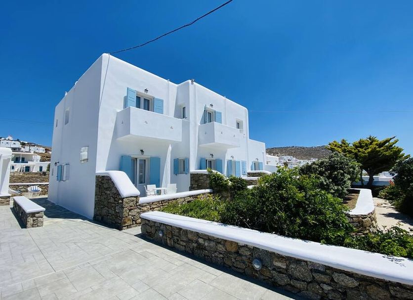 Eleftheria Hotel & Apartments in Ornos, white Cycladic-style building with balconies and garden path