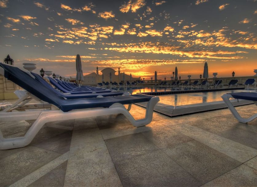 Il Mercato Hotel & Spa in Sharm el-Sheikh: rooftop pool deck with lounge chairs at sunset
