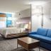 Holiday Inn Express & Suites Lake Zurich-Barrington by IHG guest room with king bed and blue sofa