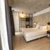 Krista Boutique Hotel Buenos Aires bedroom with king bed, wood-paneled walls, and large mirror