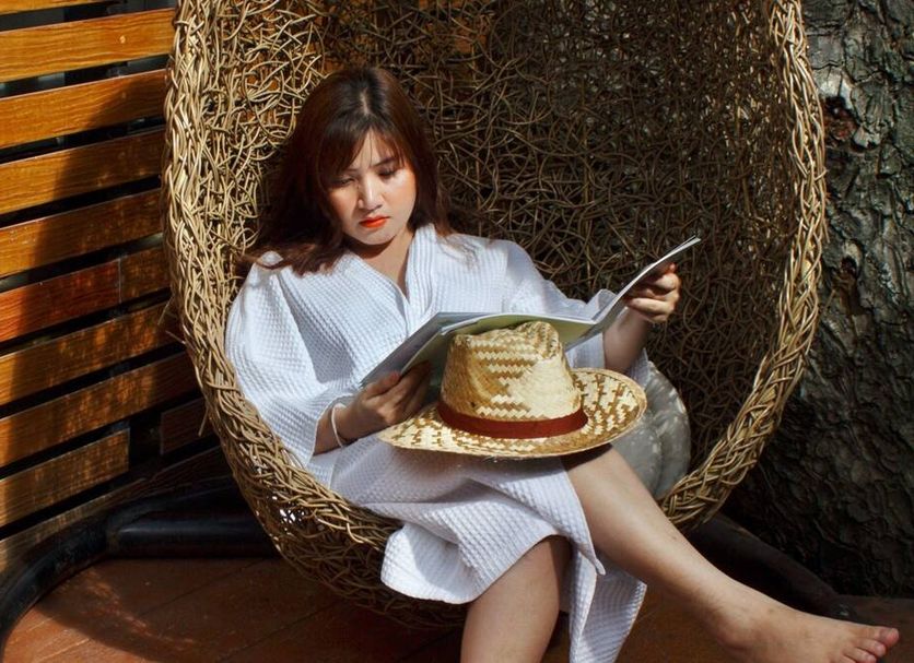 Bamboori Boutique Resort Chiang Mai: woman relaxing in a woven hanging chair with straw hat in Chiang Mai