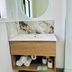Airport Gold Star Motel Auckland bathroom vanity with round mirror, sink, and rolled towels