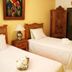 The Mexican Inn in Cabo San Lucas guest room with twin beds, wood furniture and tiled floor
