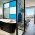 Hotel Blue Dream Palace Tripiti Resort in Limenaria: modern room with freestanding tub and sea-view balcony
