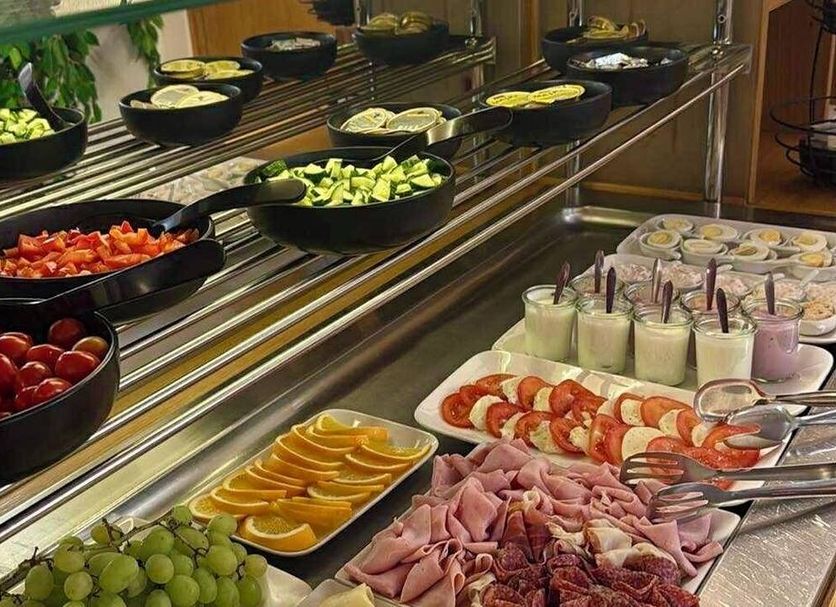 Hotel Trinity Olomouc breakfast buffet with fruit, yogurt cups, sliced citrus and cold cuts