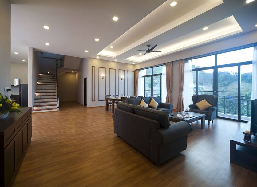 Nova Highlands Hotel Brinchang suite with living area, dining table, staircase and mountain-view balcony