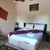 Seven Rock Cave Hotel room in Göreme with bed, chair, bedside table and colorful wall hangings.