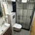 Nif Ankara Hotel bathroom with sink, wall-hung toilet, towel rack and glass shower enclosure