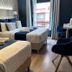 Hôtel Clairefontaine Paris guest room with two beds, desk, blue chair, and window view
