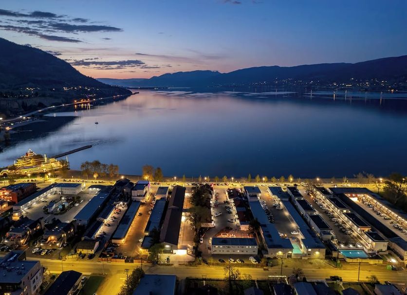 Okanagan Lakefront Resort in Penticton with a lakeside view at dusk and mountains beyond