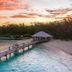 Heron Island Resort on Heron Island with a wooden jetty over turquoise water at sunset