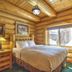 Hibernation Station in West Yellowstone guest room with log cabin walls, bed, and large window