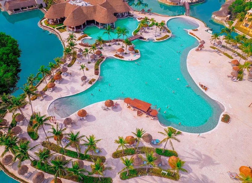 Aerial view of Grand Palladium White Sand Resort & Spa in Akumal with lagoon pool, beach, and palm trees