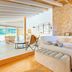 Sa Rota d'en Palerm in Lloret de Vistalegre, bright rustic bedroom with stone wall and mountain-view balcony