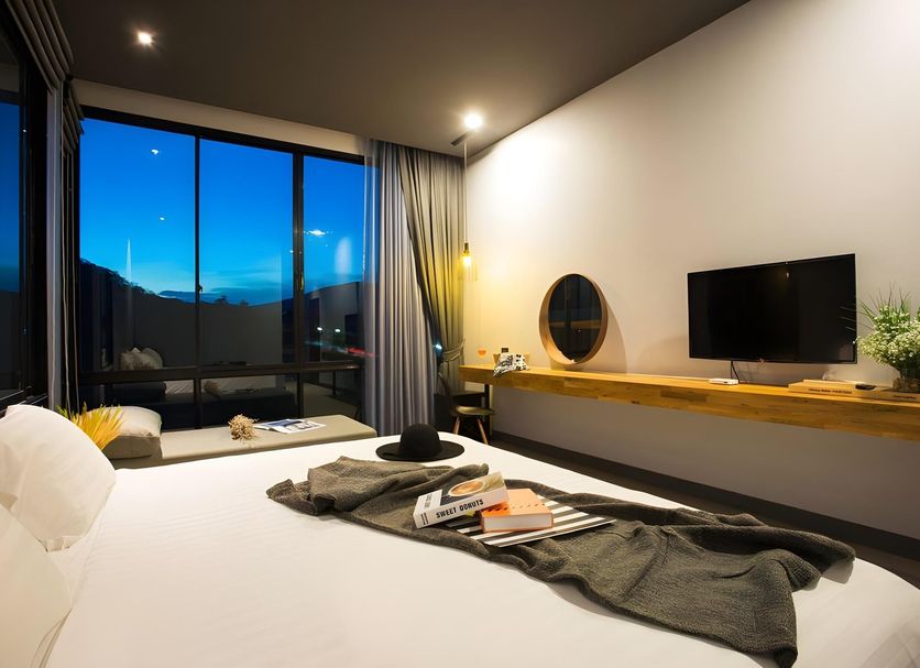 Hotel Together in Pak Chong room with large window, bed, wall-mounted TV and work desk