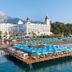 Amara Dolce Vita Luxury in Tekirova with beachfront pier, blue sun loungers and mountain backdrop