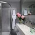 Una Hotels Forte Dei Marmi bathroom with glass shower, floating sink, mirror and pink flowers
