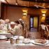 Refugio Del Pintor in Tilcara dining room with rustic wooden ceiling and guests at tables.