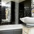 The Shankly Hotel, Liverpool: bathroom with freestanding tub, vessel sink, and black tiled walls